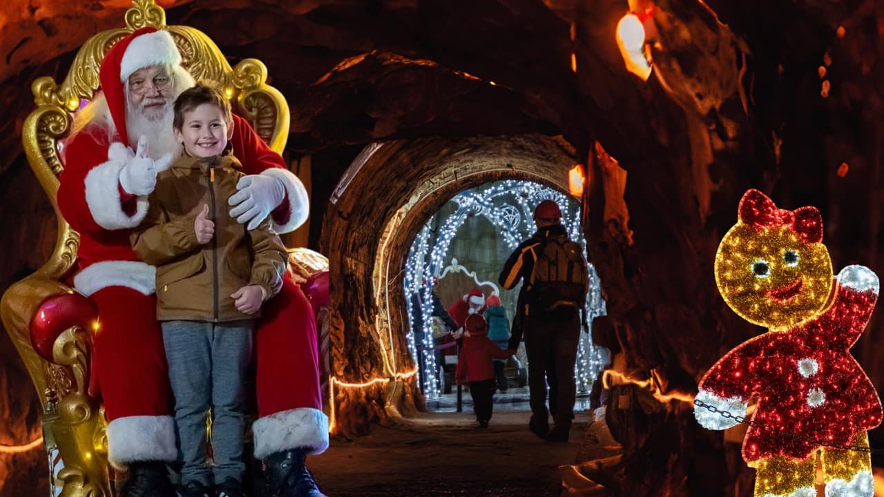 Bambino con Babbo Natale sul trono nella Grotta sotterranea di Ornavasso, illuminata da luci di Natale