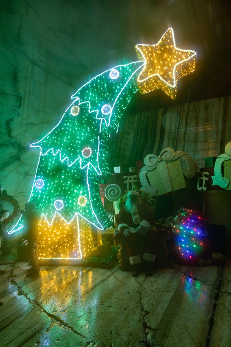 Babbo Natale sul trono nella Grotta sotterranea di Ornavasso, con albero di luci a stella cometa e sacco dei doni
