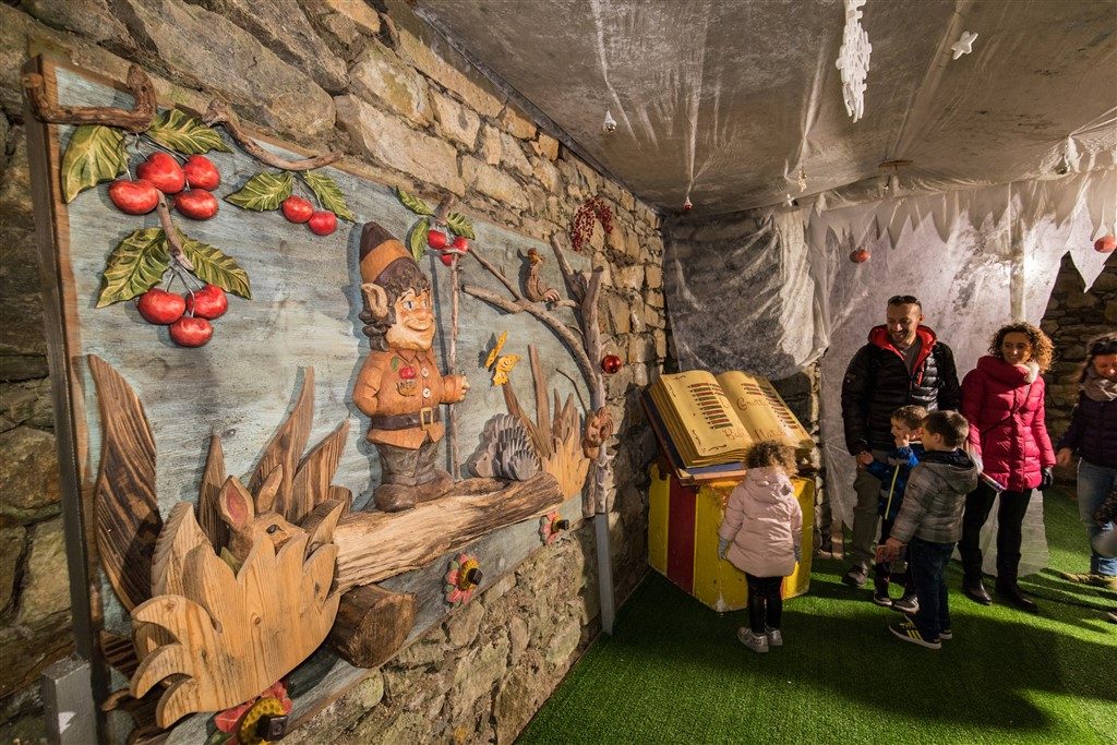 Famiglie nella Grotta di Babbo Natale di Ornavasso: libro gigante, intagli di legno e installazioni nei cunicoli sotterranei