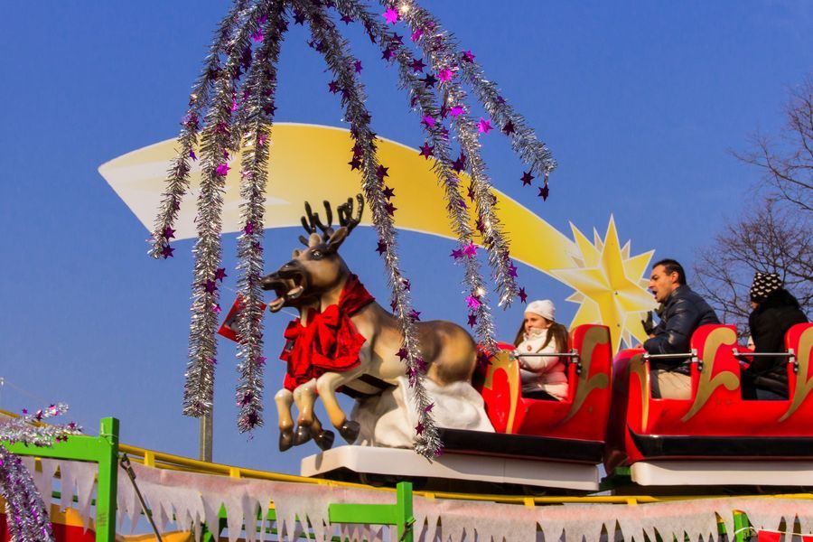 Attrazione Slitta volante di Babbo Natale con slitta rossa e renna, bambini a bordo sotto il cielo di Ornavasso